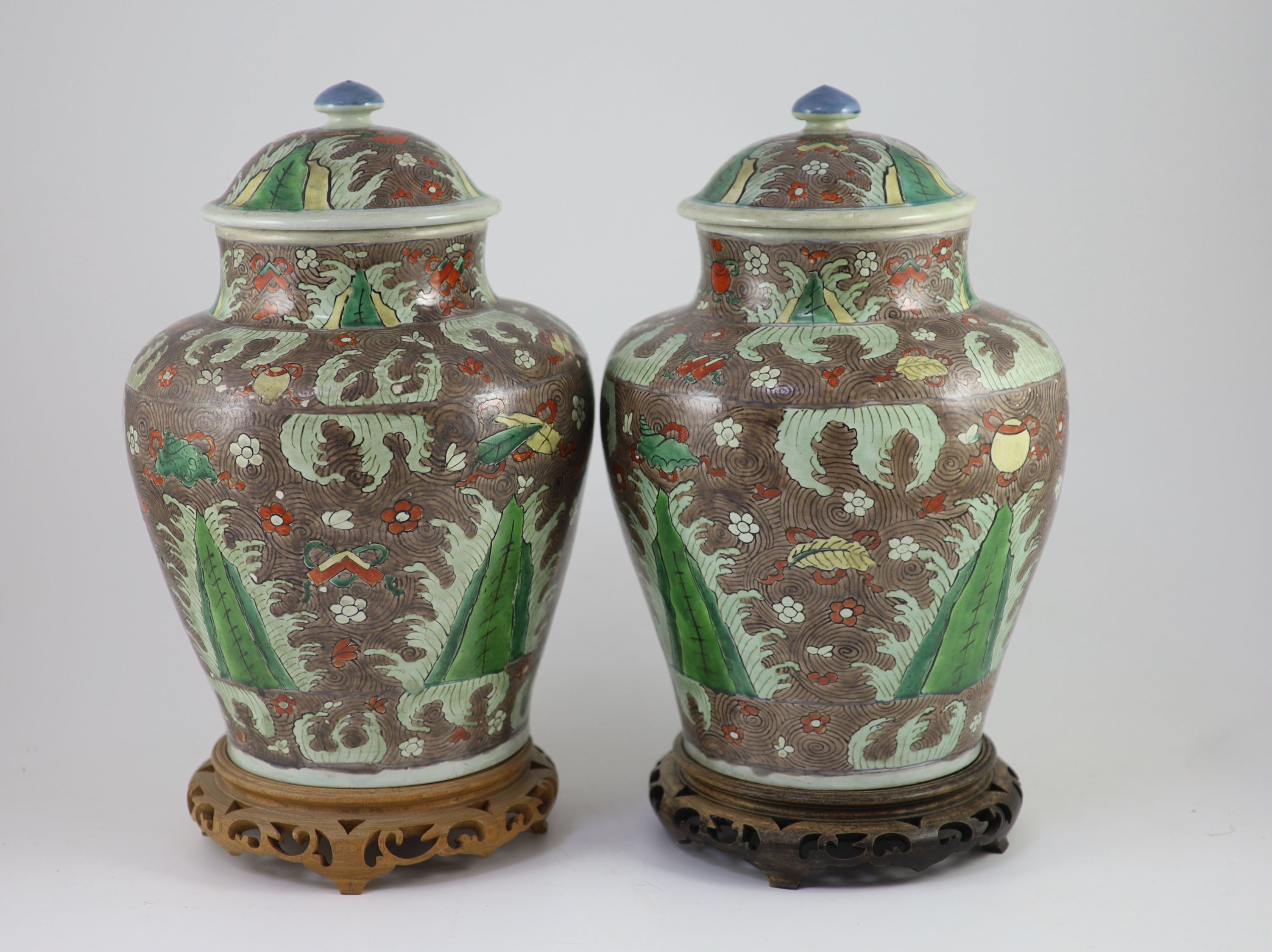 A pair of Chinese enamelled porcelain jars and covers, in Transitional style, 34cm high, wood stands